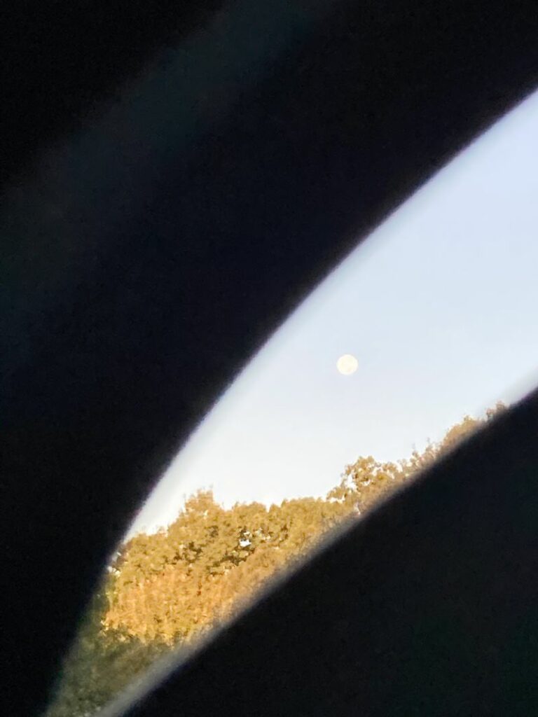 this is another sunrise with moon out but through the lens of the porta potty